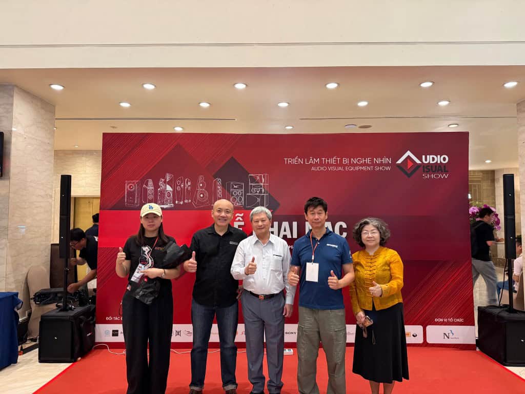 Group of people at audio visual equipment show with Eleven Audio branding.
